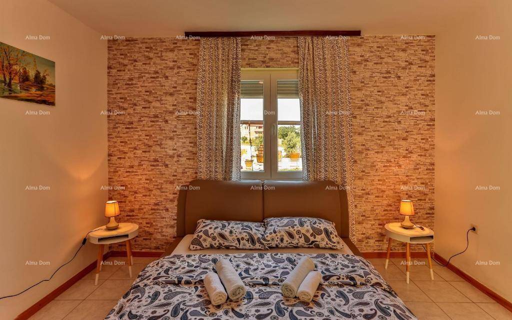 Gemütliches Schlafzimmer mit Doppelbett, Nachttischen und dekorativer Ziegelwand.