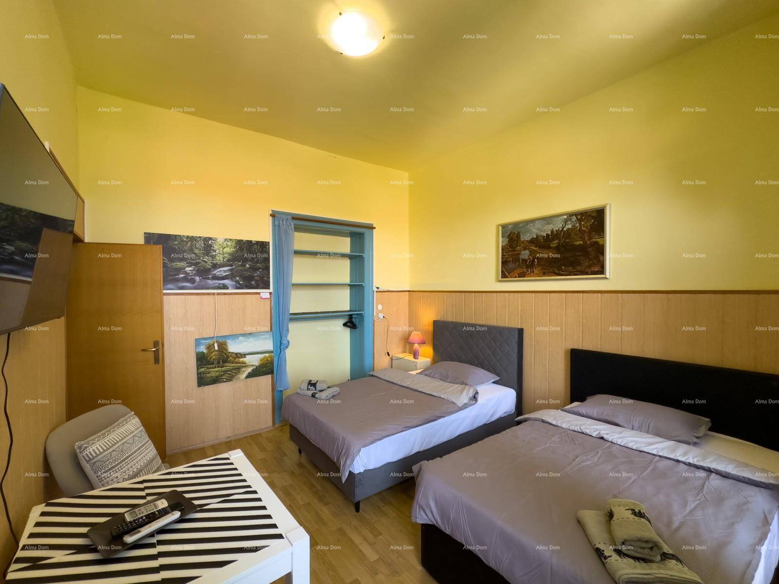 Gemütliches Schlafzimmer mit zwei Einzelbetten, Tisch und gelben Wänden.