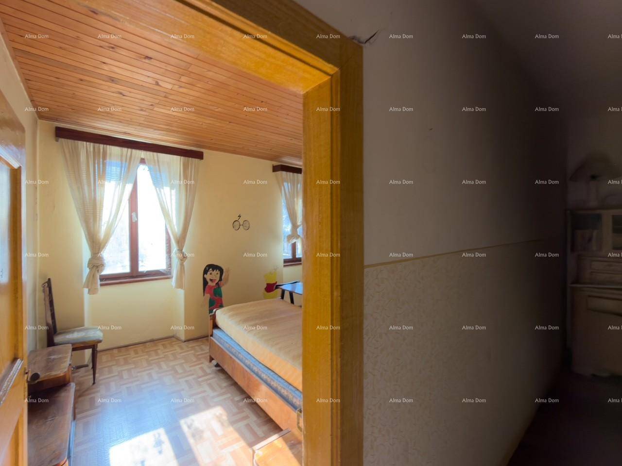 Schlafzimmer mit Holzbalkendecke, zwei Betten und Fenstern mit Vorhängen.