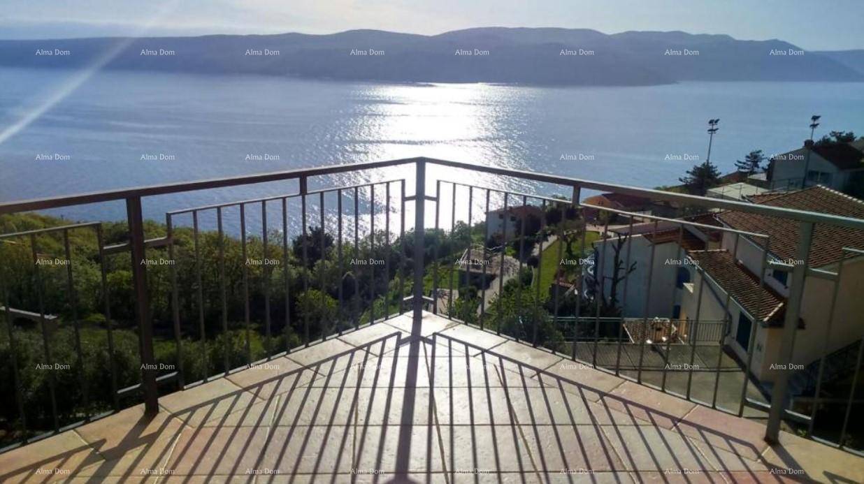 Große Terrasse mit Metallgeländer und weitem Blick auf das glitzernde Meer und die Berge.