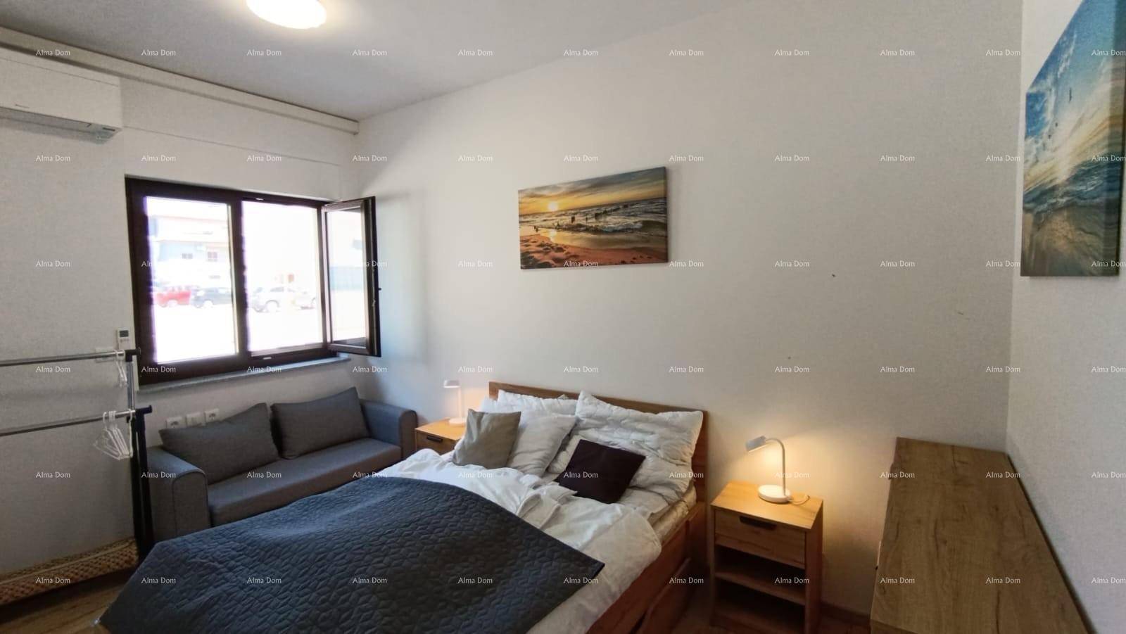 Helles Schlafzimmer mit Holzbett, Sofa und Blick nach draußen durch das Fenster.