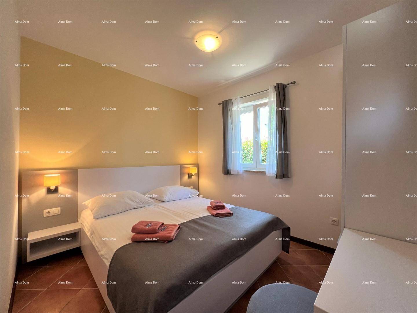 Helles Schlafzimmer mit Doppelbett, Nachttischen und einem Fenster, das Tageslicht hereinlässt.