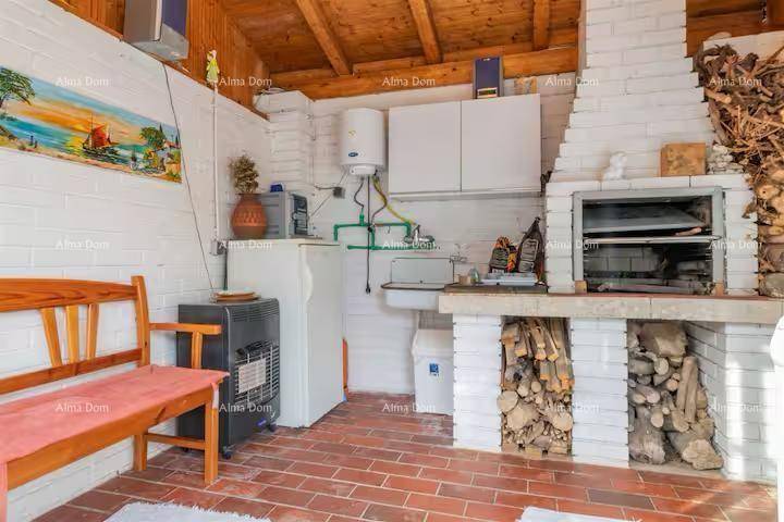 Rustikale Außenküche mit gemauertem Grill, Holzbank und sichtbaren Deckenbalken.