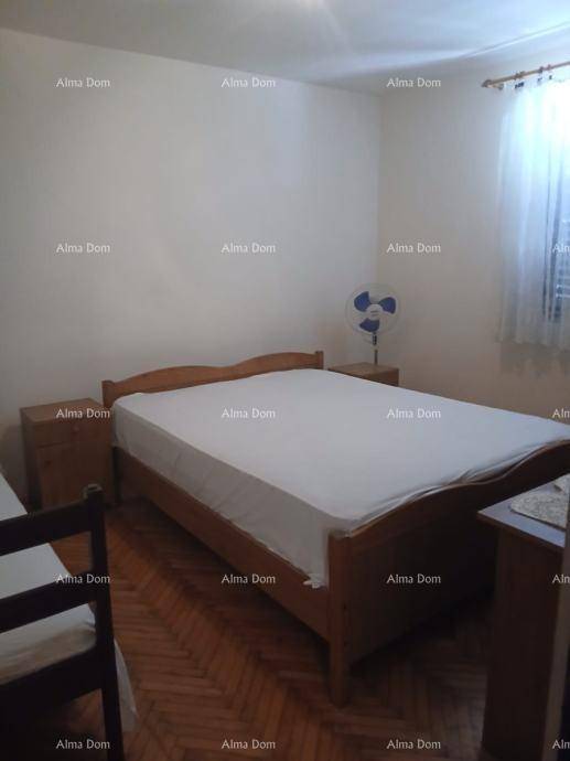 Helles Schlafzimmer mit Doppelbett aus Holz, Nachttischen und Parkettboden.
