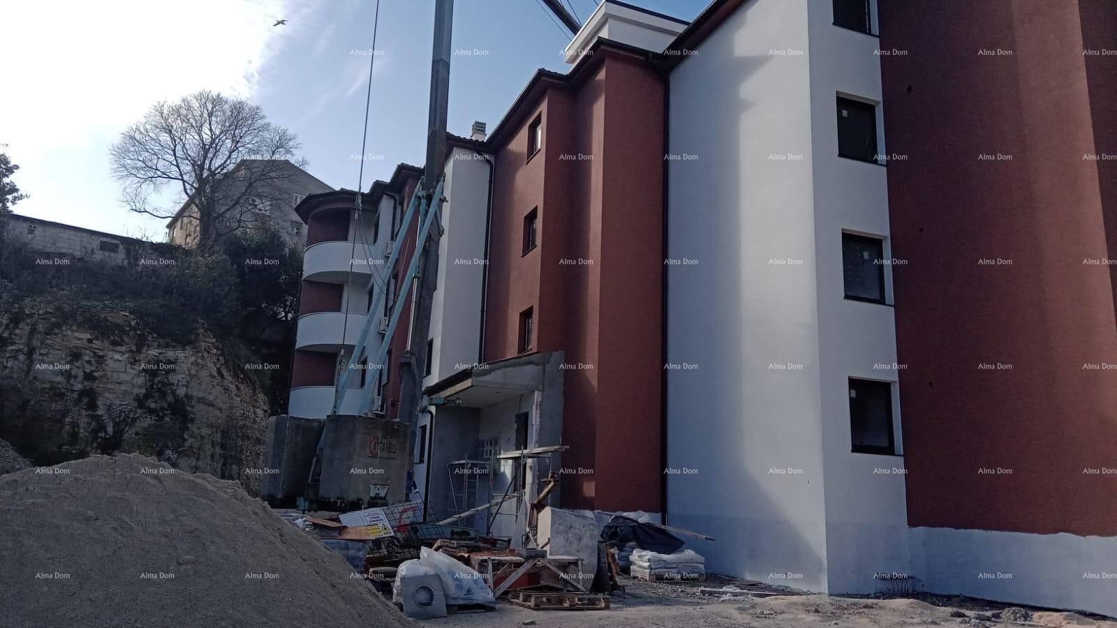 Baustelle eines modernen Mehrfamilienhauses mit teilweise fertiggestellter Fassade und Erdarbeiten.