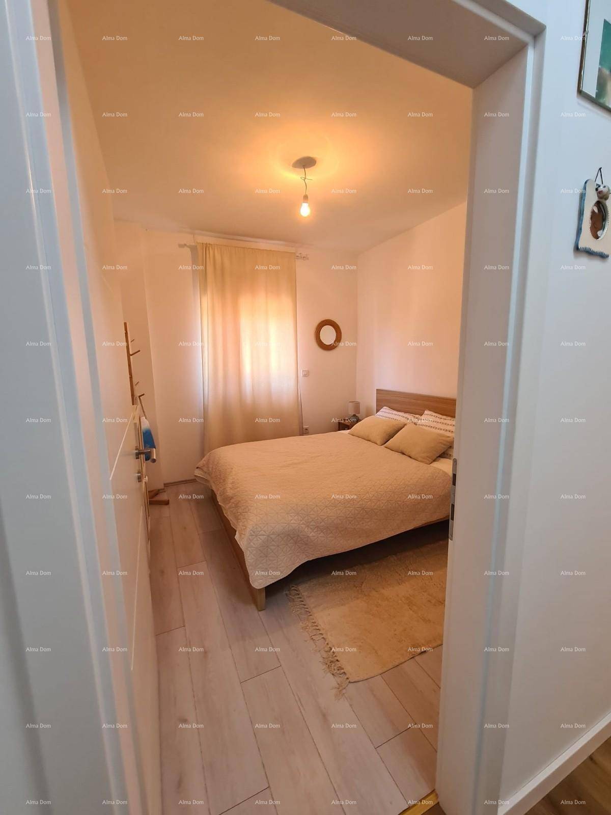 Einladendes Schlafzimmer mit hellem Holzboden und gemütlichem Doppelbett, gesehen durch eine Türöffnung.
