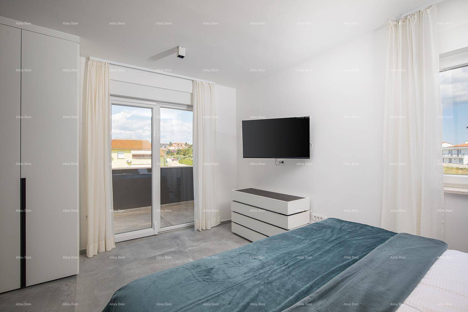 Schlafzimmer mit Doppelbett, Kleiderschrank, Fernseher und Zugang zu einem Balkon.
