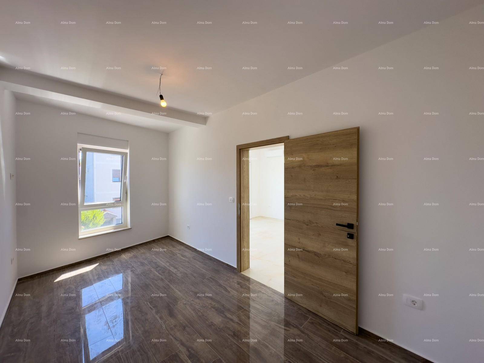 Modernes Schlafzimmer mit dunklen Fliesen und einer Holztür, die zu einem weiteren Raum führt.