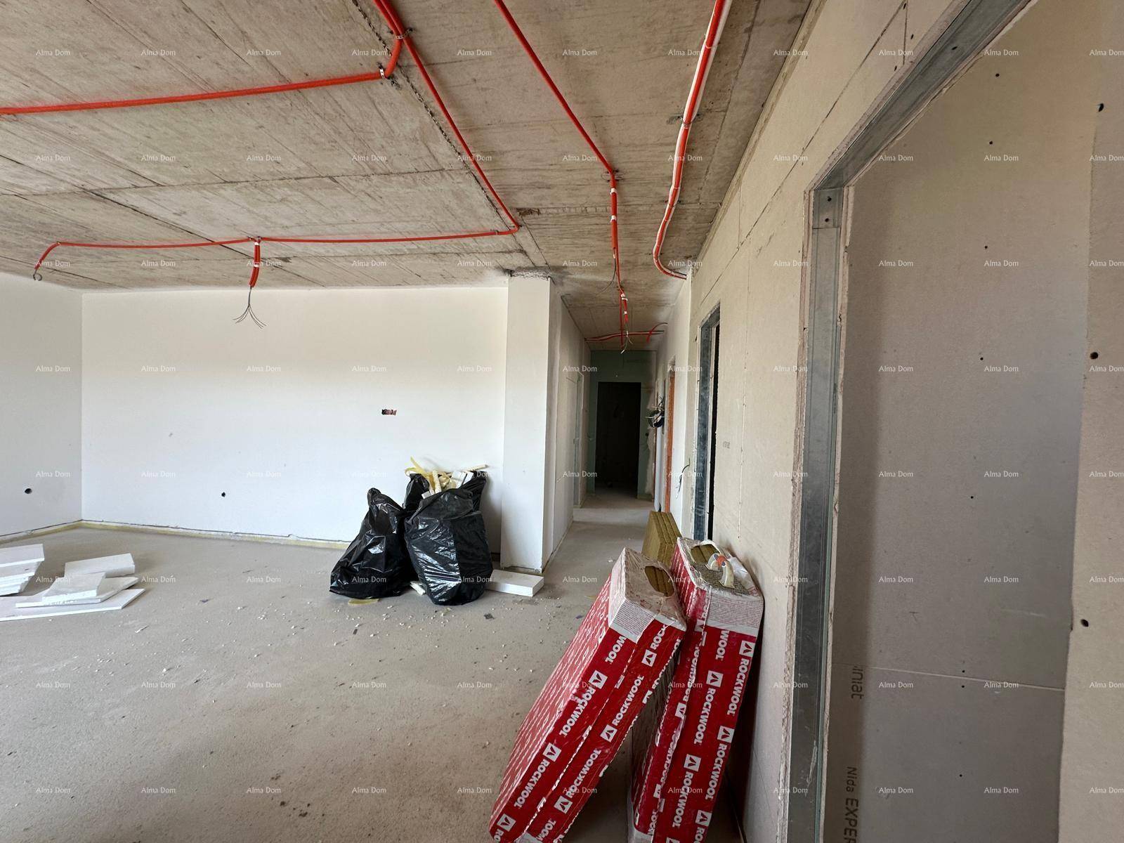 Großer offener Wohnbereich im Rohbau mit sichtbaren Deckenleitungen und Baumaterialien.