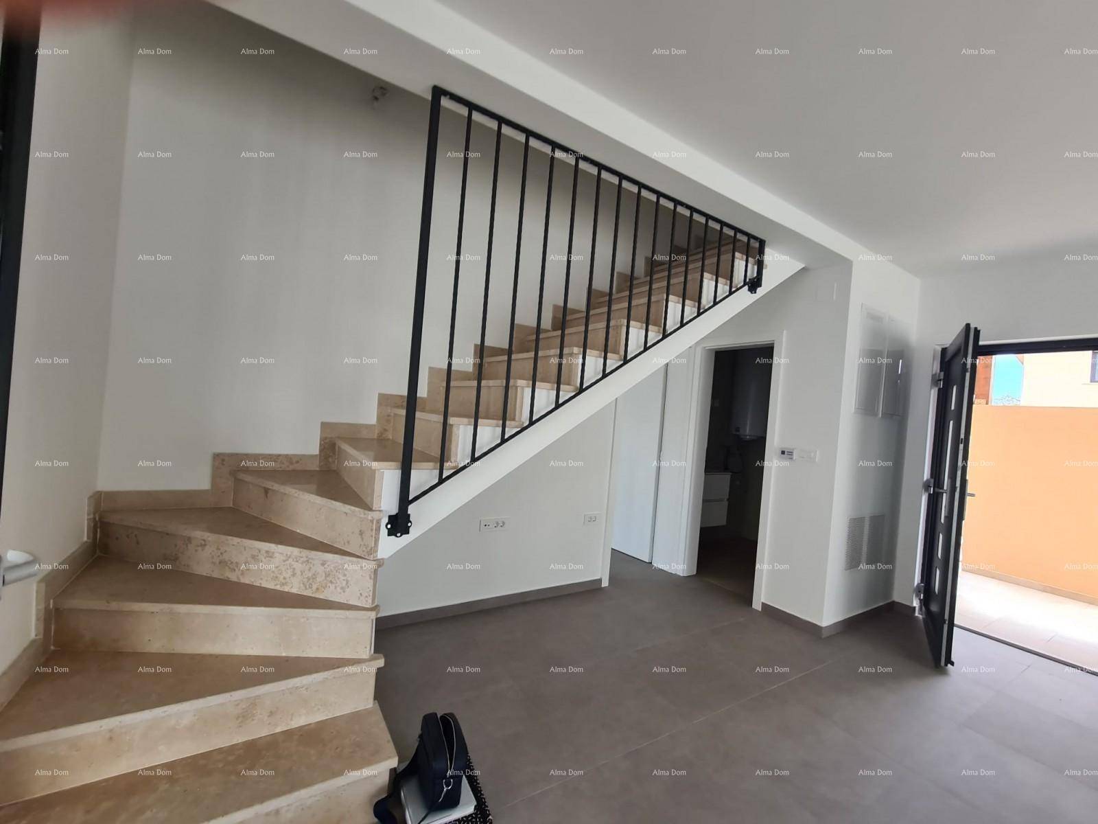 Eingangsbereich mit eleganter Steintreppe und modernem Geländer, führt in die obere Etage.