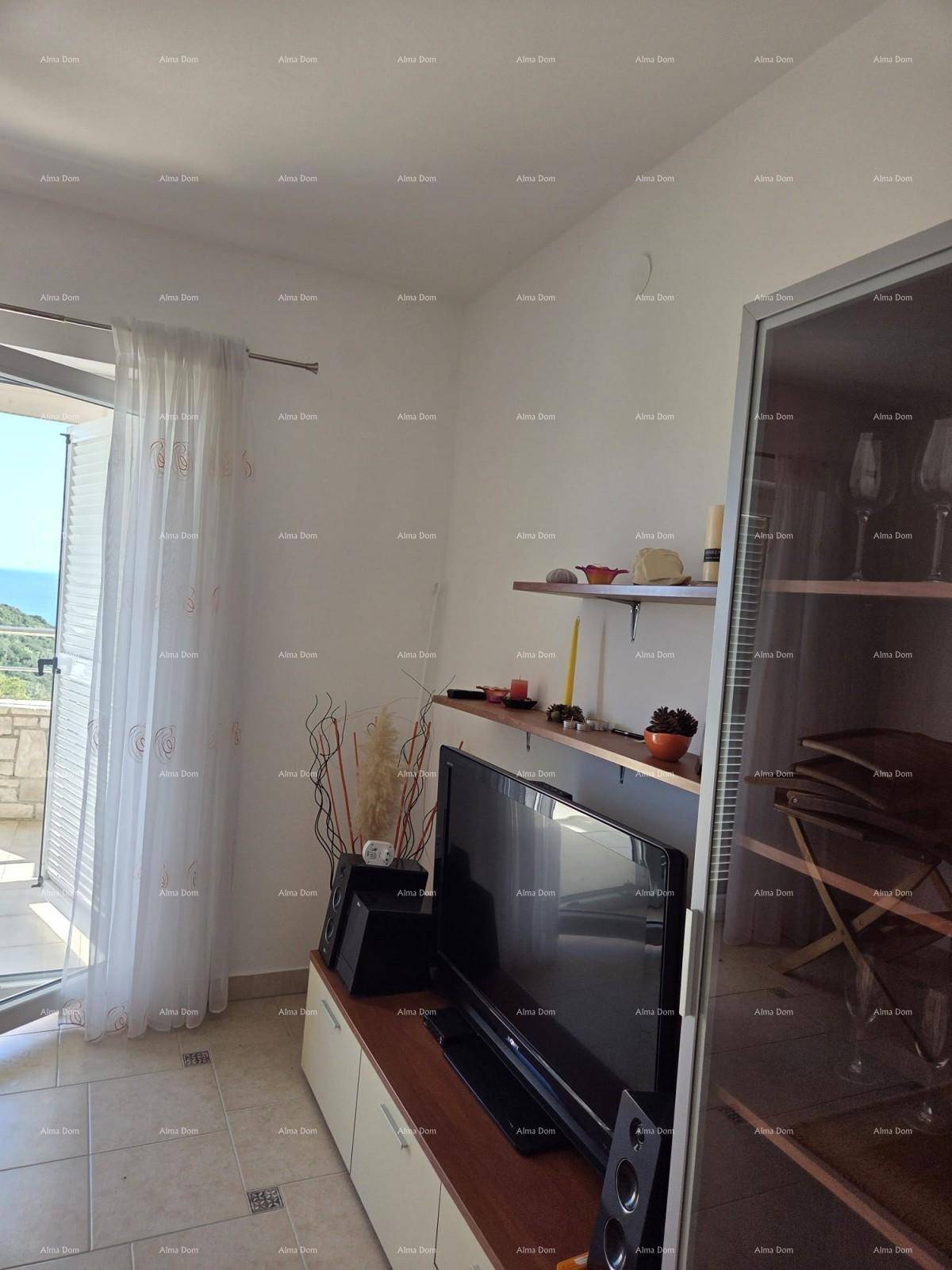 Wohnzimmer mit TV-Möbeln, Regal und Vorhängen am Terrassenzugang.