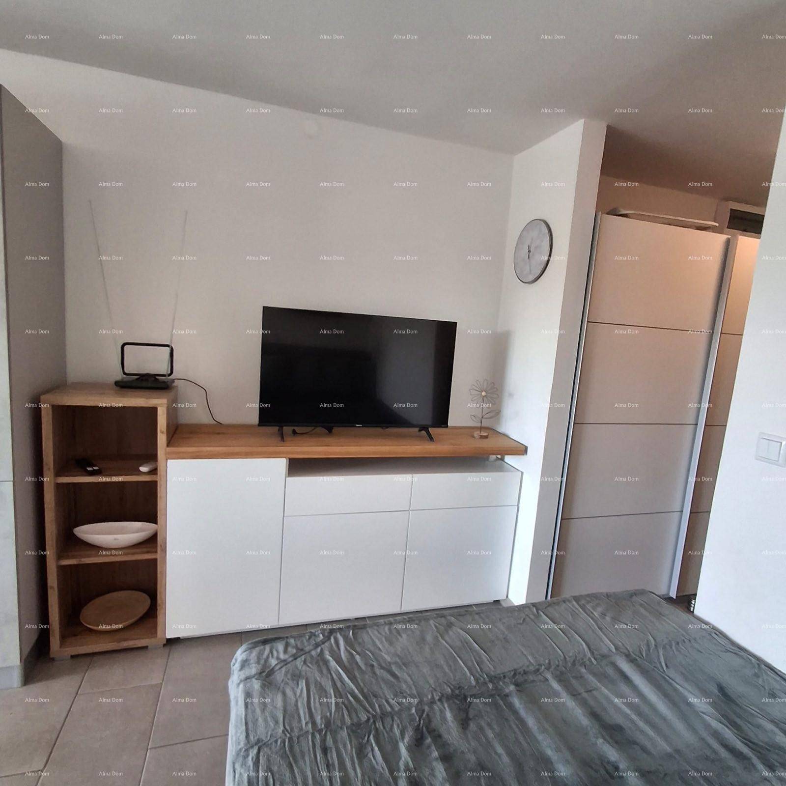 Wohnbereich mit Fernseher, modernem Sideboard und integrierten Schränken.