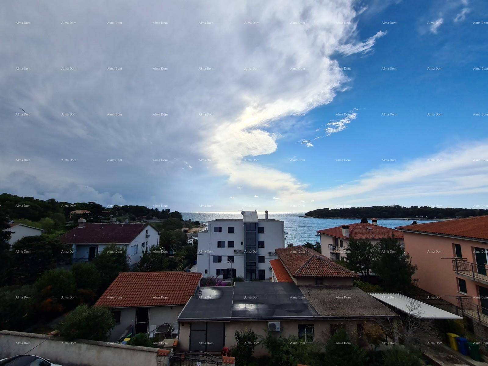 Panoramablick auf das Meer und die umliegende Wohngegend unter einem bewölkten Himmel.