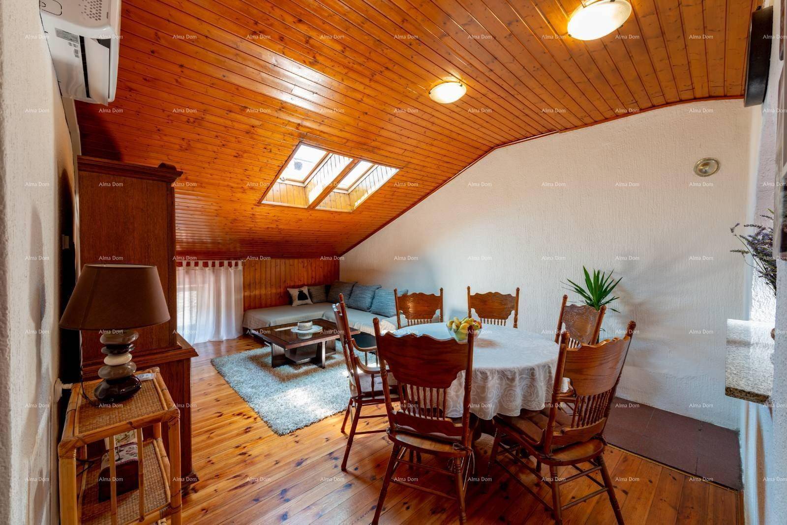 Heller Wohn- und Essbereich im Dachgeschoss mit Holzboden, Esstisch und Sofa.