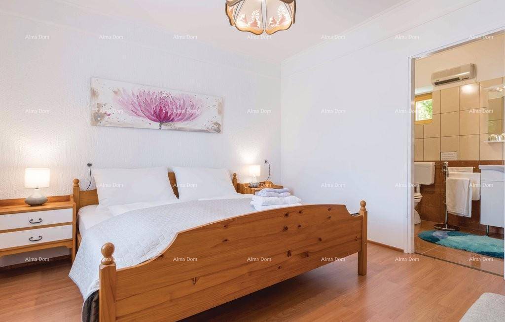 Schlafzimmer mit Holzboden, Doppelbett und direktem Zugang zu einem Badezimmer.