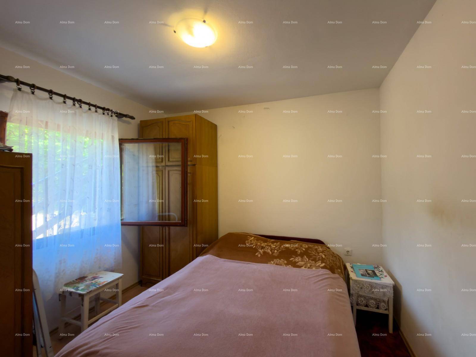 Schlafzimmer mit Doppelbett, Holzschrank und Fenster, bietet eine ruhige Rückzugsmöglichkeit.
