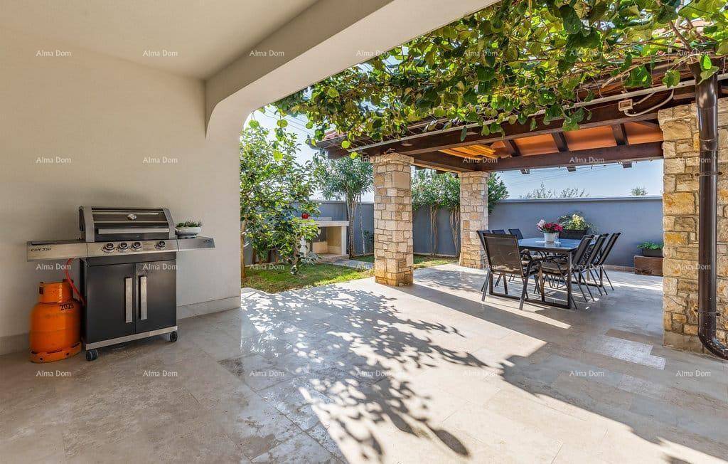 Sonnige Terrasse mit Grillbereich, Esstisch und Blick ins Grüne, perfekt für gesellige Stunden.