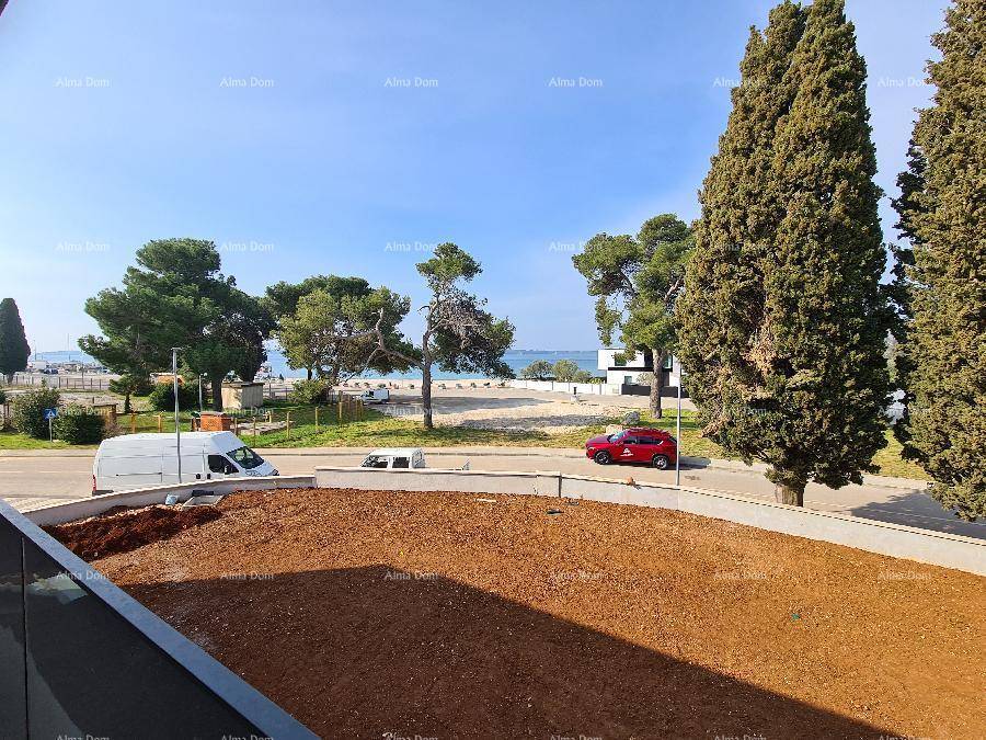 Panoramablick vom Balkon auf das Meer, den Strand und die umliegende grüne Landschaft.