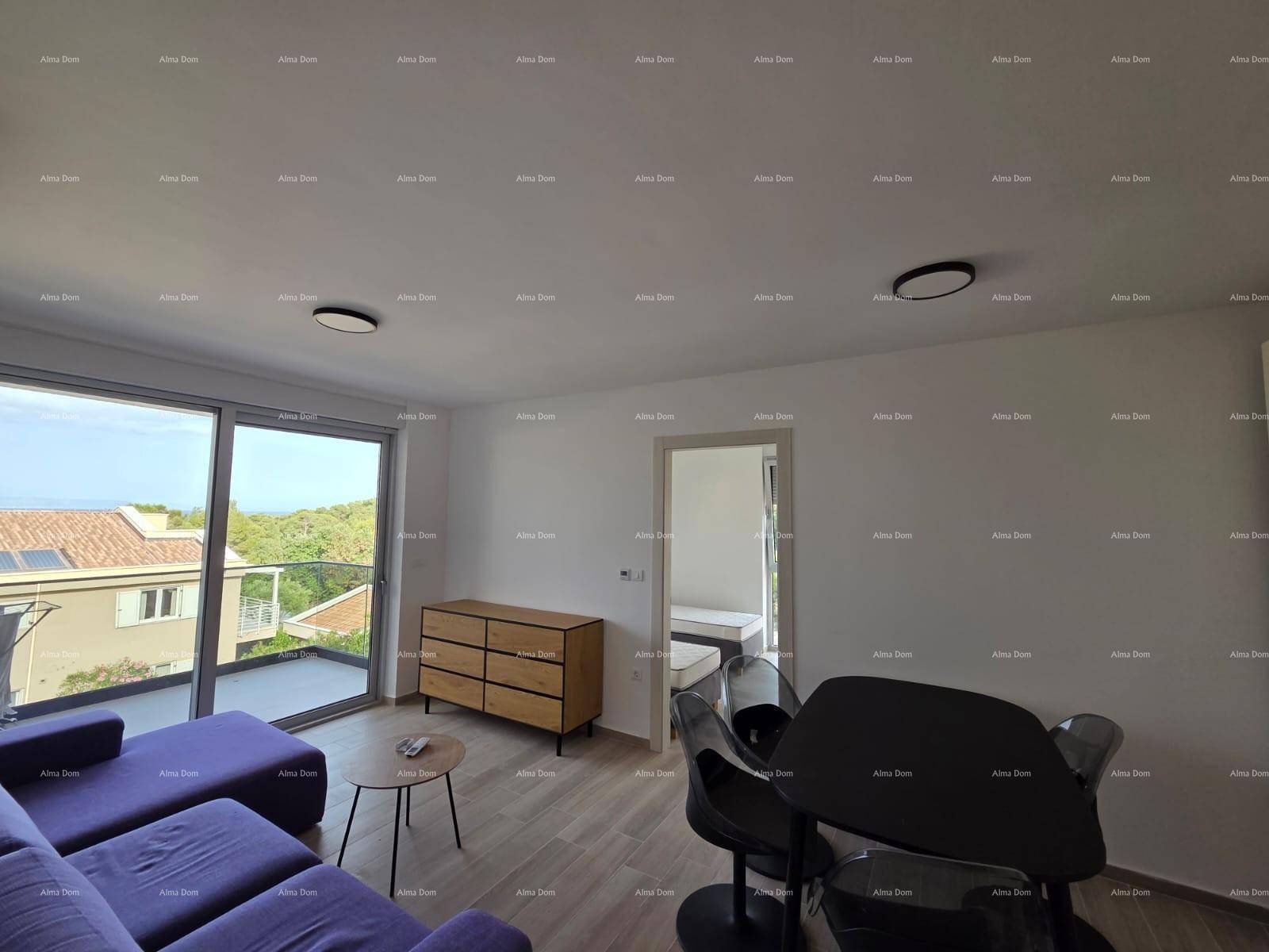 Helles Wohnzimmer mit lila Sofa, Kommode und großen Schiebetüren zum Balkon mit Aussicht.