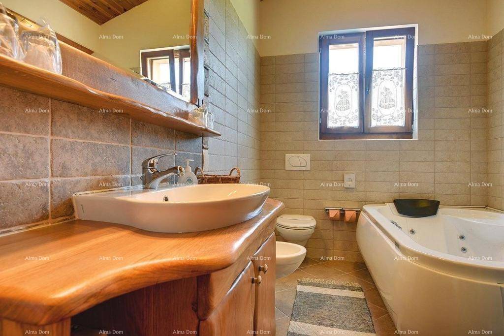 Rustikales Badezimmer mit Badewanne, Holzwaschtisch und Fliesen.