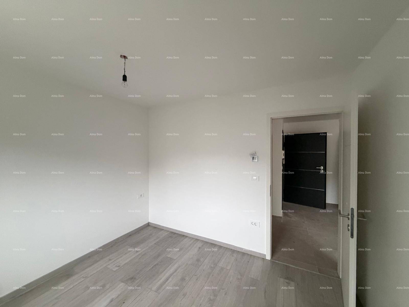 Geräumiges Schlafzimmer im Rohbau mit Laminatboden und Blick auf die Tür.