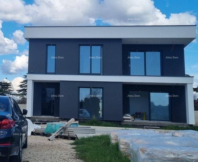 Neubau eines modernen Hauses mit dunkler Fassade, großen Fenstern und weißem Dachrand.
