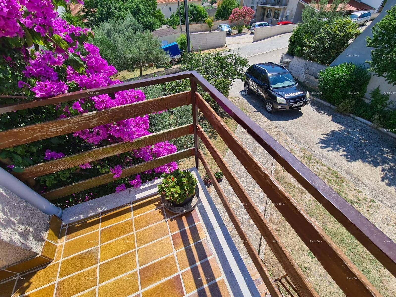 Balkon mit Holzgeländer und blühenden Pflanzen, bietet einen Blick auf die Straße und die Umgebung.