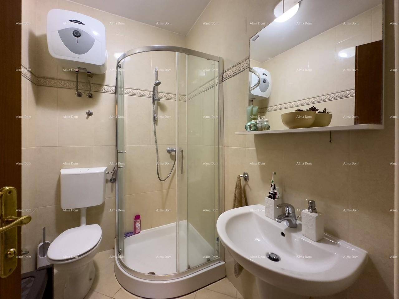 Modernes Badezimmer mit Duschkabine, WC und Waschbecken, komplett gefliest und funktional.