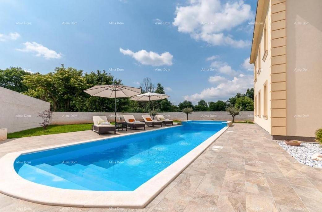 Langer, rechteckiger Poolbereich mit gefliestem Rand und Liegeflächen unter blauem Himmel.