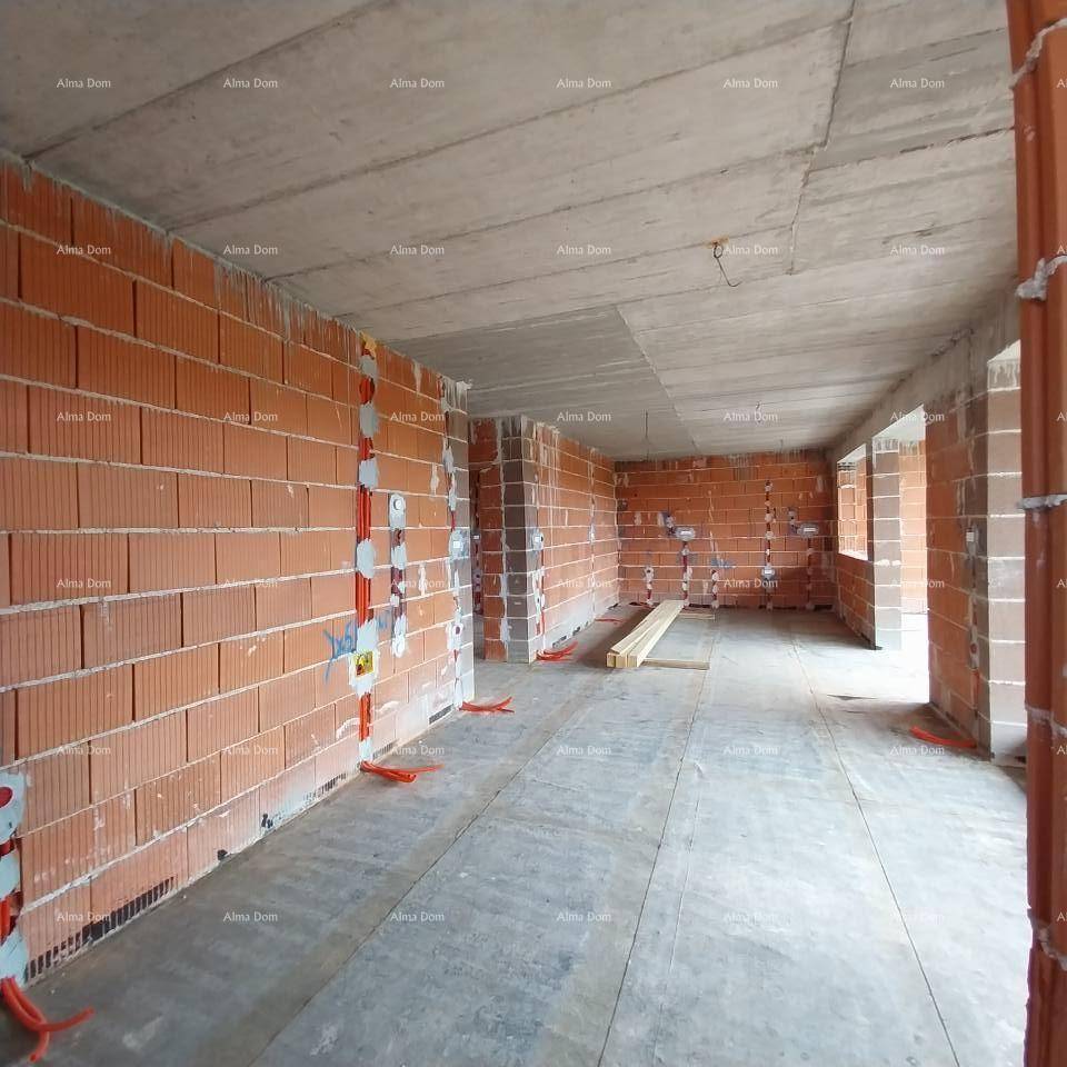 Großer Innenraum im Rohbau mit Ziegelwänden, Betonboden und vorbereiteten Elektroinstallationen.
