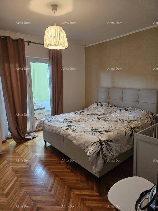 Gemütliches Schlafzimmer mit Parkettboden, Doppelbett und Zugang zum Balkon.