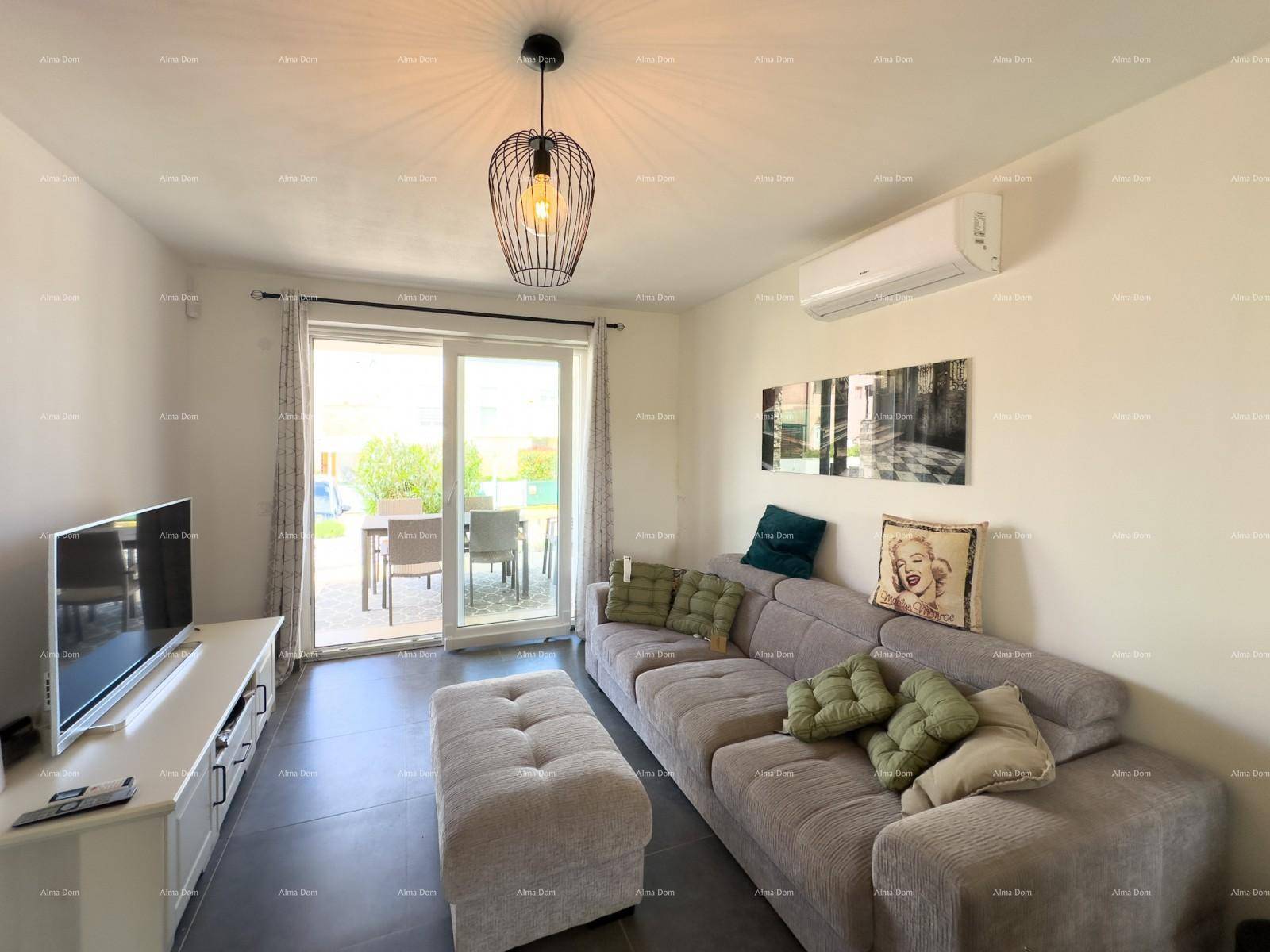 Heller Wohnbereich mit bequemer Couch, Klimaanlage und Zugang zur Terrasse.