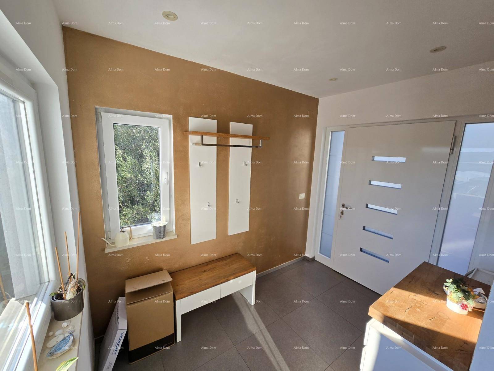 Heller Eingangsbereich mit beiger Wand, Fenster und praktischer Garderobenbank.