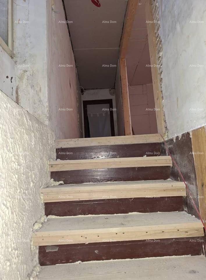 Treppenhaus im Bau mit Holzstufen und freiliegenden Wänden, die auf Fertigstellung warten.