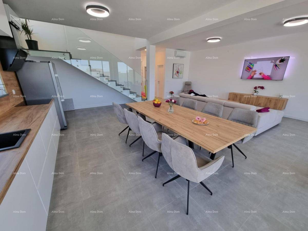 Geräumiger Wohn- und Essbereich mit moderner Einrichtung und einer eleganten Treppe zum Obergeschoss.