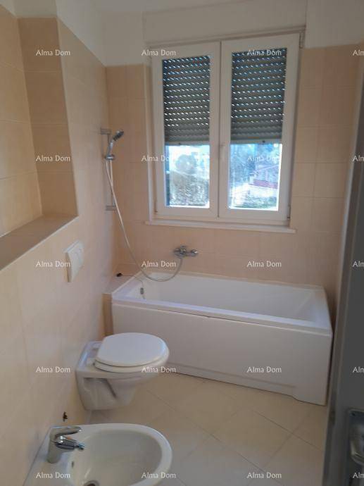 Badezimmer mit Badewanne, Toilette, Bidet und Fenster, ausgestattet mit hellen Fliesen.