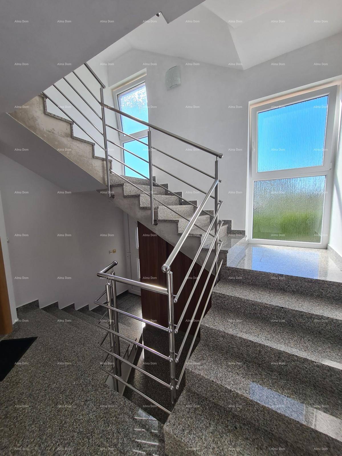 Modernes Treppenhaus mit Granitstufen und Edelstahlgeländer, hell durch große Fenster.