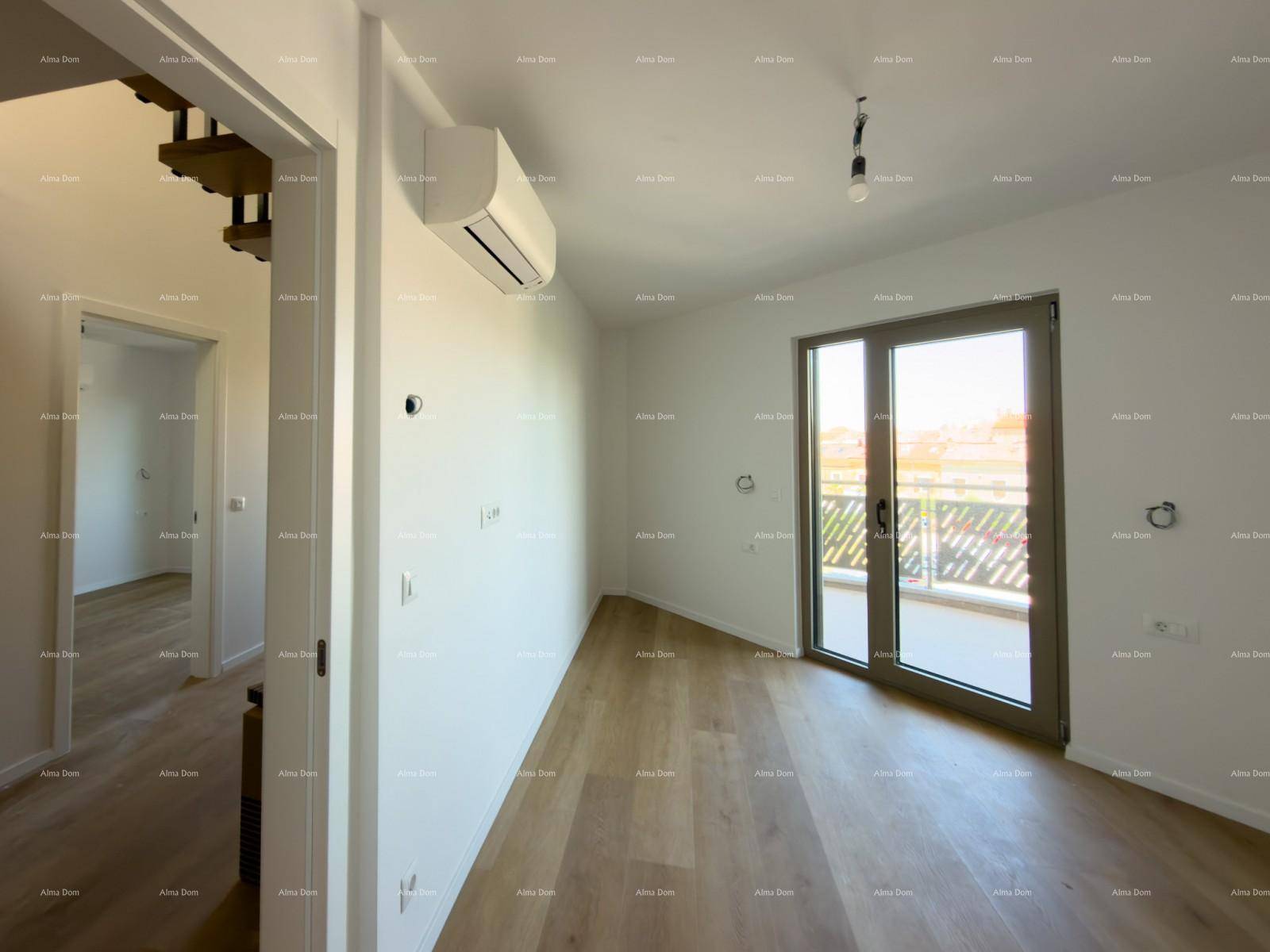 Heller Raum mit Holzboden, Klimaanlage und Zugang zu einem sonnigen Balkon.