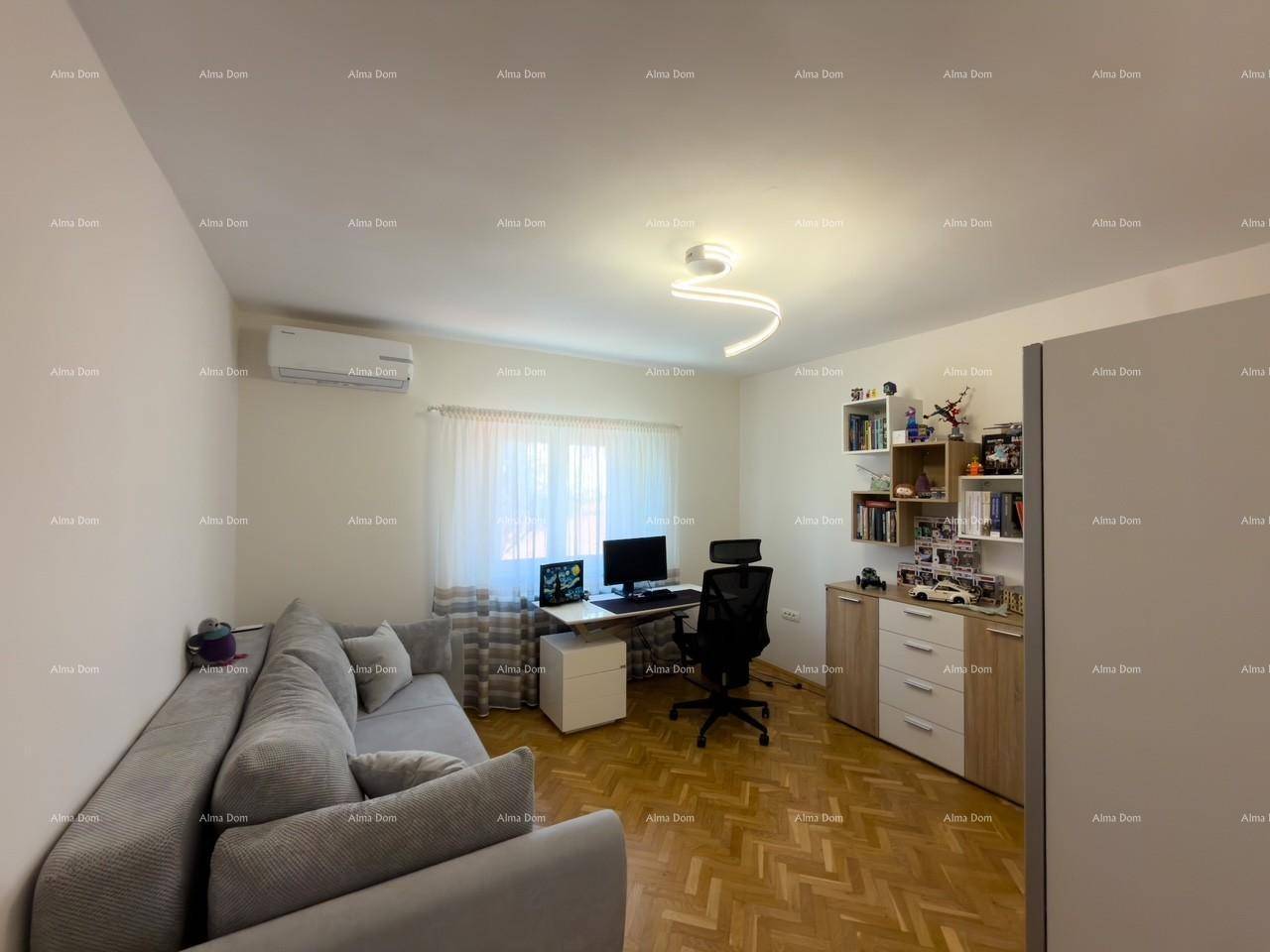 Modernes Arbeitszimmer mit Sofa, Schreibtisch und Regalen, ausgestattet mit Klimaanlage.