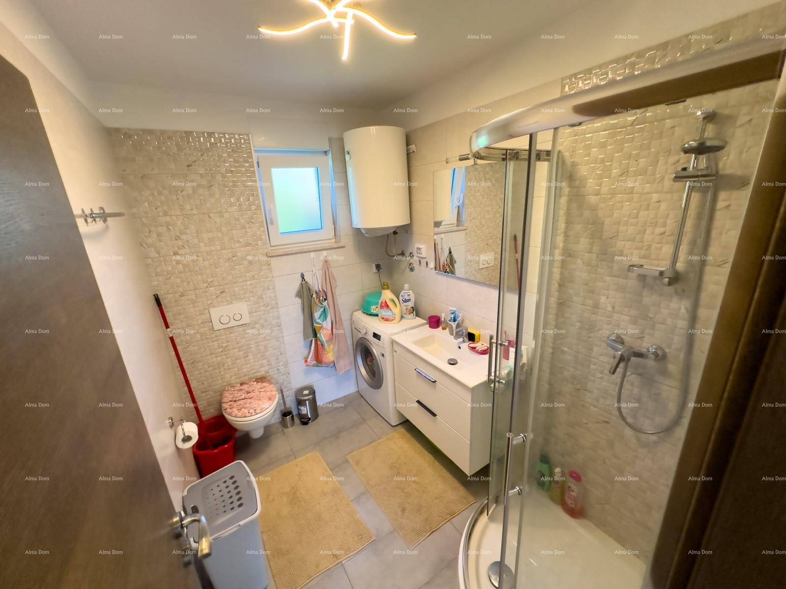 Helles Badezimmer mit Duschkabine, WC, Waschbecken und Waschmaschine, gut beleuchtet.