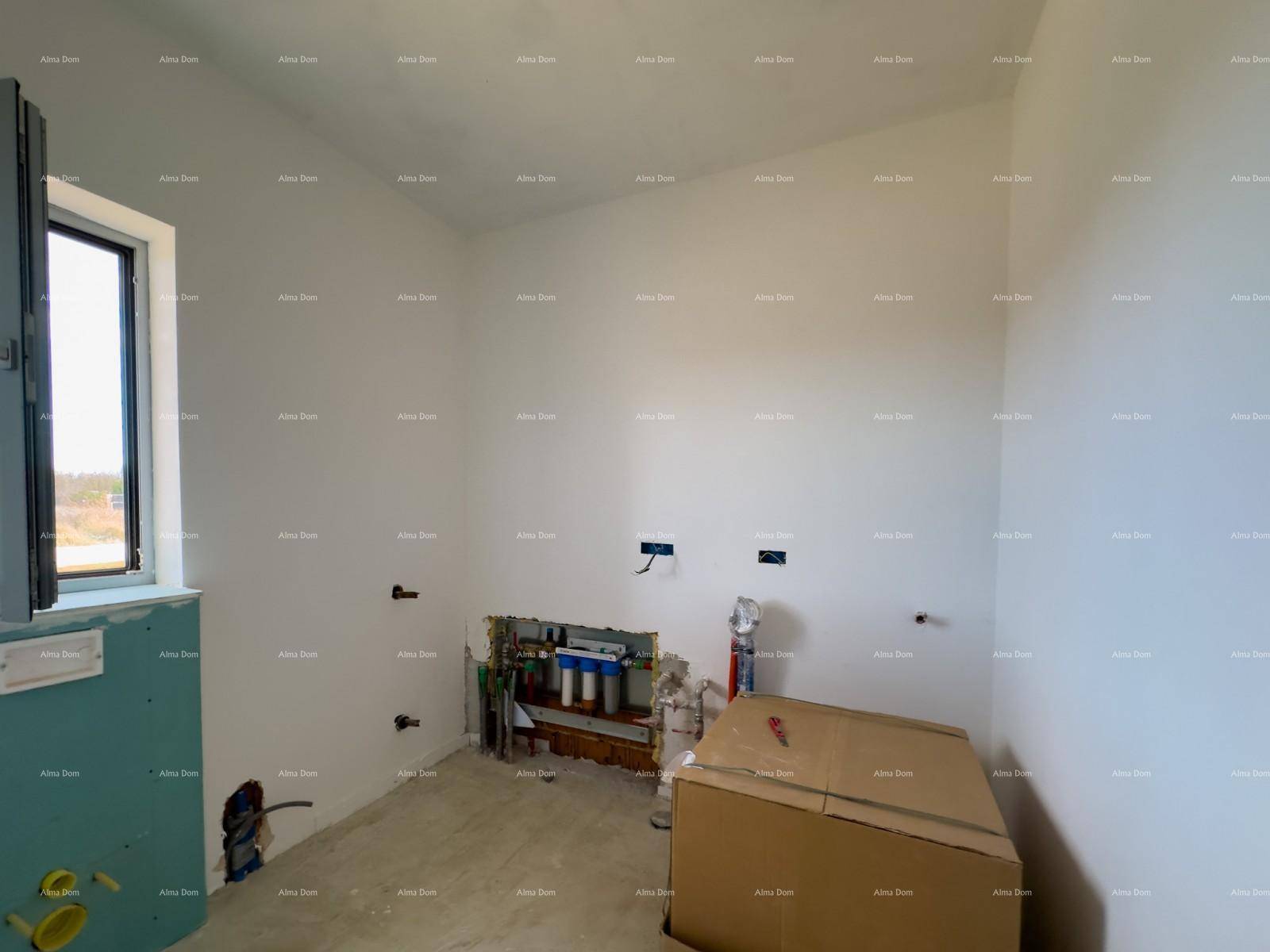 Unfertiger Hauswirtschaftsraum mit Wasseranschlüssen und einem Fenster, bereit für die Installation.