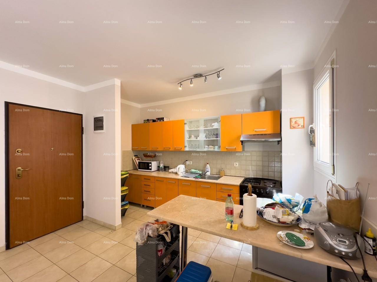 Funktionale Küche mit leuchtend orangefarbenen Schränken und praktischer Arbeitsfläche, gut beleuchtet.