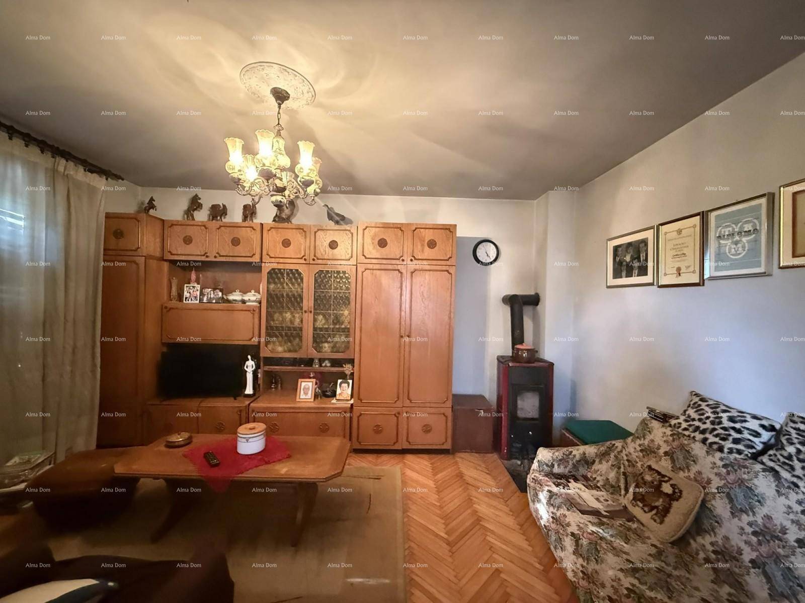 Wohnzimmer im traditionellen Stil mit Holzmöbeln, Kaminofen und Parkettboden.