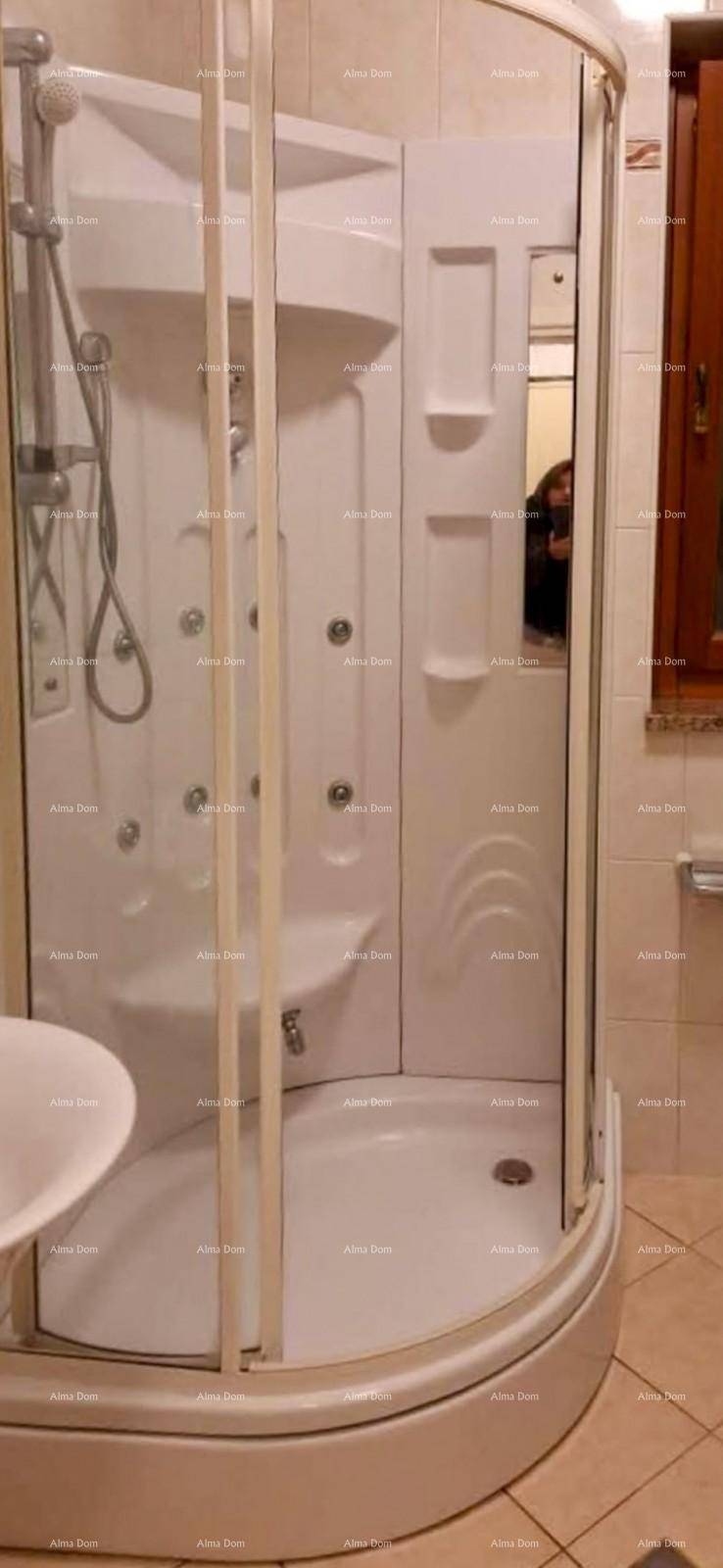 Eckduschkabine mit Glasabtrennung und mehreren Massagedüsen in einem gefliesten Badezimmer.