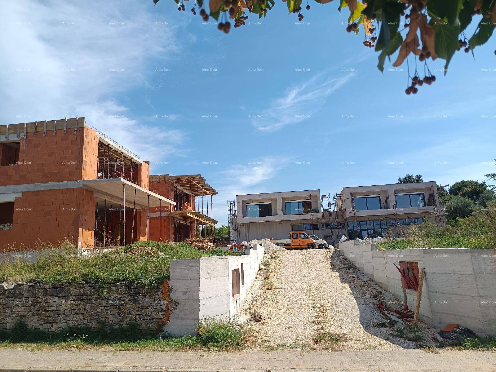 Übersicht der Baustelle mit im Bau befindlichen Gebäuden und bereits fertiggestellten modernen Strukturen im Hintergrund.