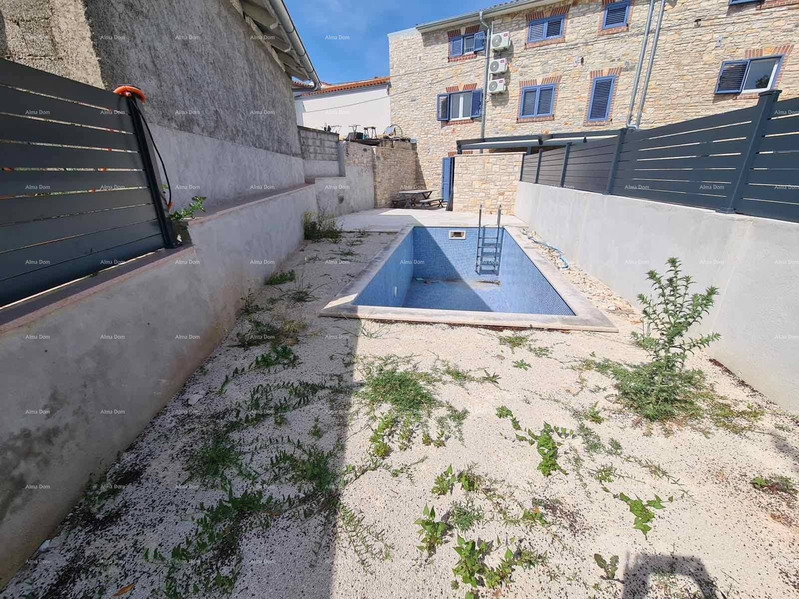 Außenbereich mit kleinem Pool, umgeben von Kies und einer Steinmauer.