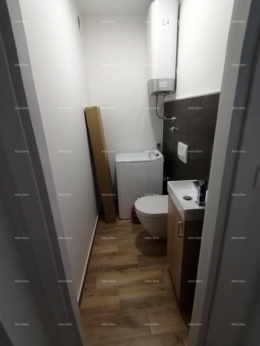 Kleines WC mit Waschbecken, Toilette und Waschmaschine.