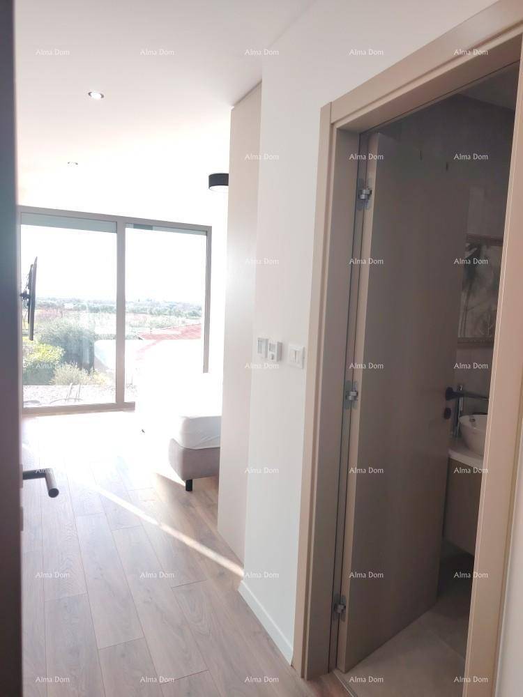 Heller Flur führt zu einem Schlafzimmer mit großen Fenstern und angrenzendem Badezimmer.