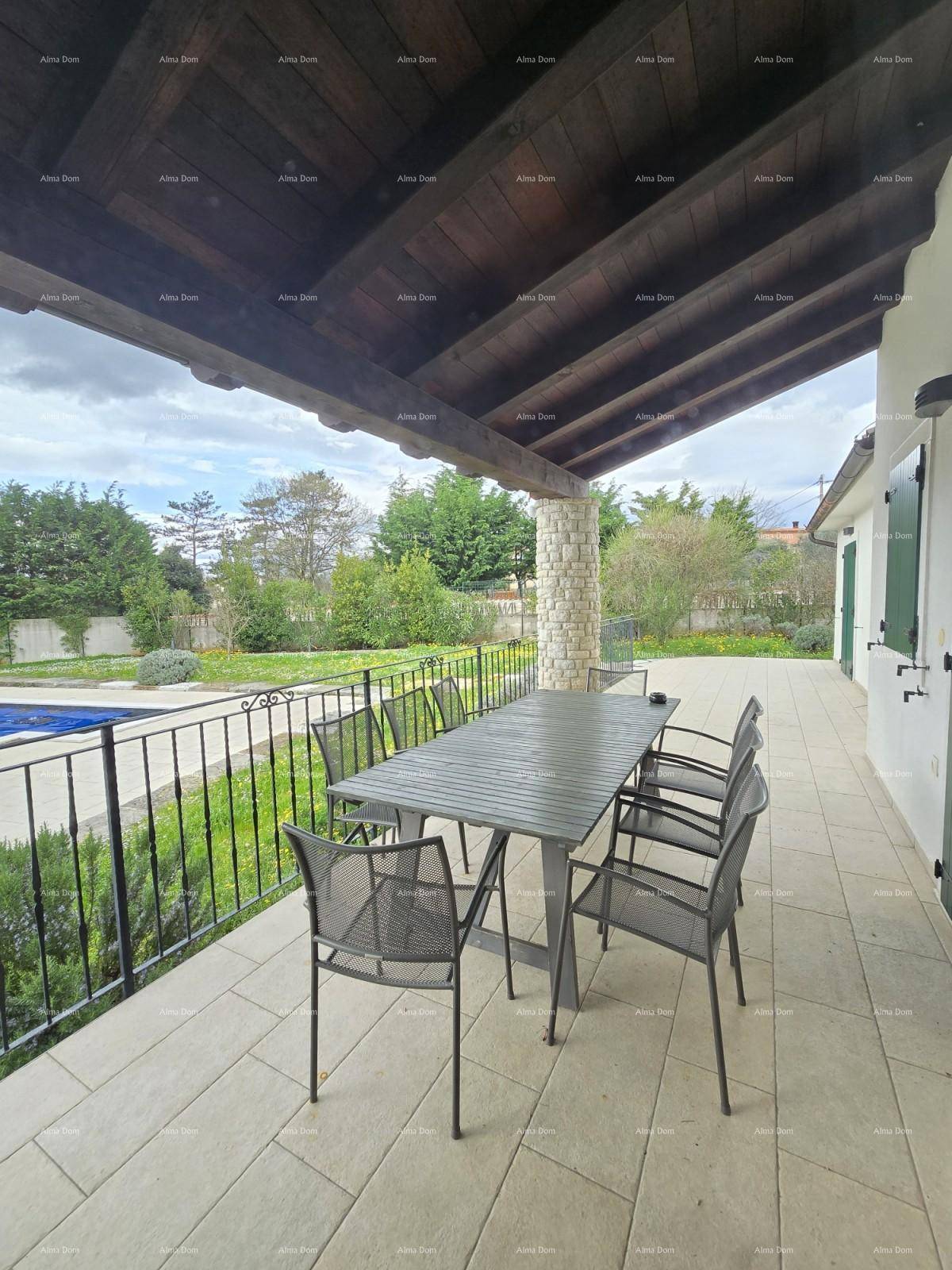 Überdachte Terrasse mit Esstisch und Stühlen, ideal für Mahlzeiten im Freien mit Blick ins Grüne.