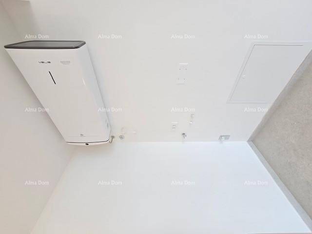 Kleiner Hauswirtschaftsraum mit Warmwasserbereiter und Zugangsklappe, praktisch und funktional.